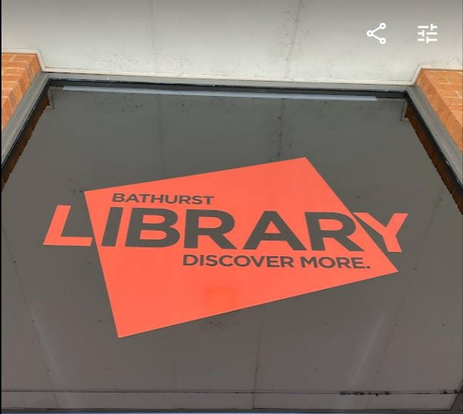 Bathurst Library window with the name Barhurst Library  and the words Discover More printed on the window in an orange large sticker.